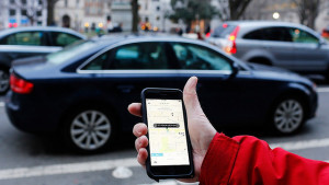 An UBER application is shown as cars drive by in Washington, DC. (Andrew Caballero-Reynolds/AFP/Getty Images)